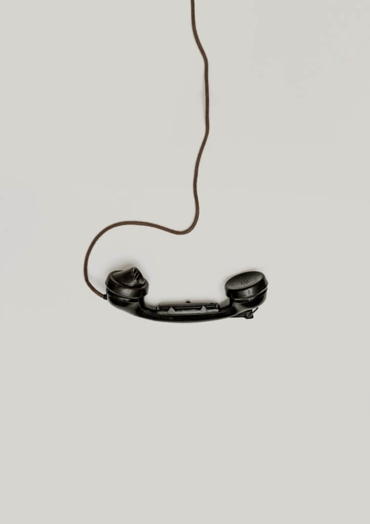stara słuchawka telefonu w stylu retro leży na beżowym blacie